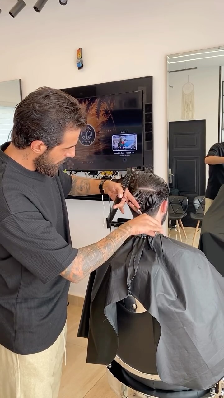 Mimo working on a client's haircut in the studio